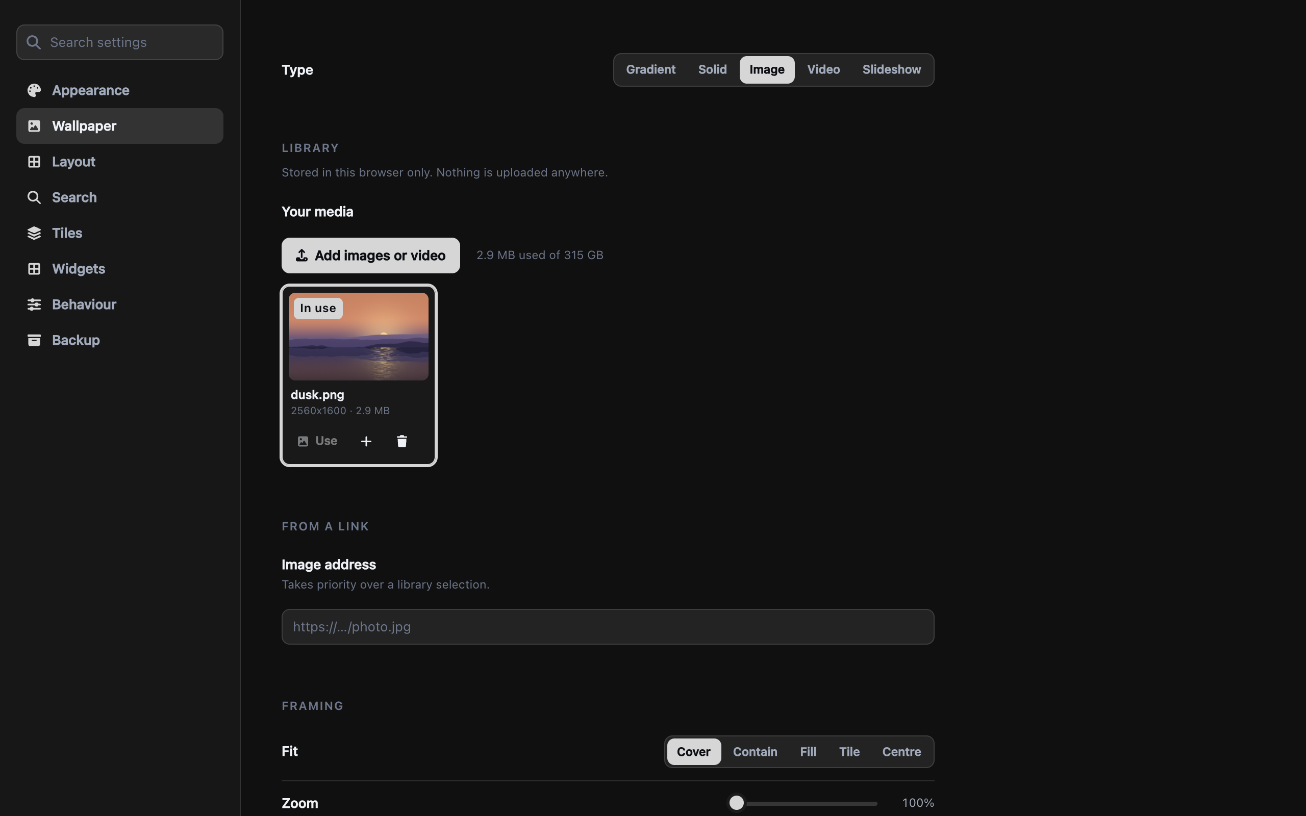 The Wallpaper settings section: a type switch offering gradient, solid, image, video and slideshow; a media library holding one image marked 'In use'; a field for an image address; and framing controls for fit, zoom and slow drift.